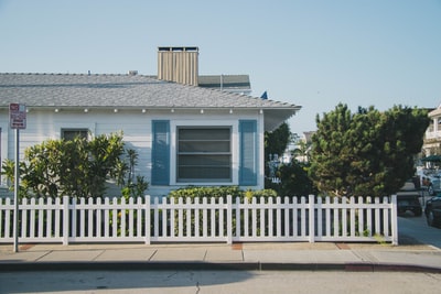 篱笆旁边的白色和蓝色房子
